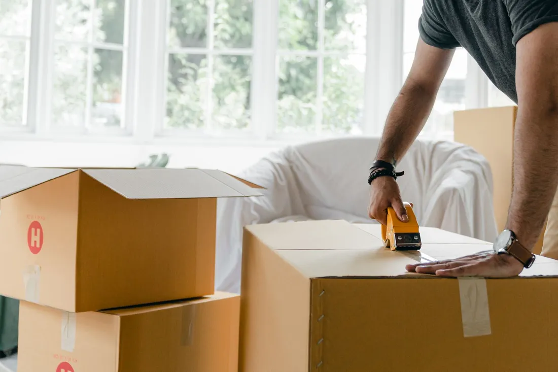 Gepackte Umzugskartons stehen im Wohnzimmer für den Festpreisumzug bereit